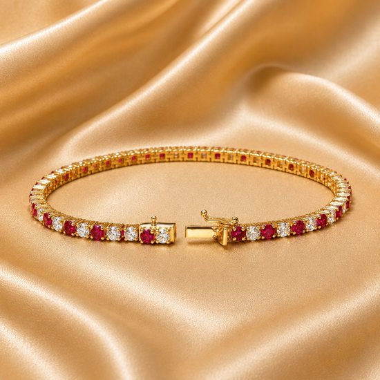 A gold tennis bracelet adorned with round-cut pinkish-red and clear gemstones, displayed on a draped beige satin fabric background.